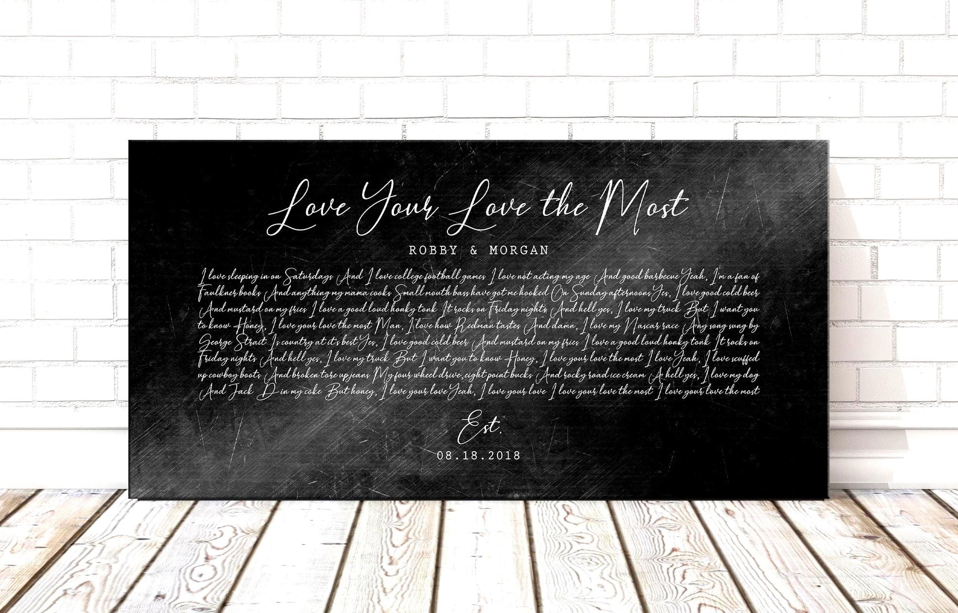 Black distressed metal song lyric art, personalized lyrics plaque on iron alloy displayed on wood plank floor.