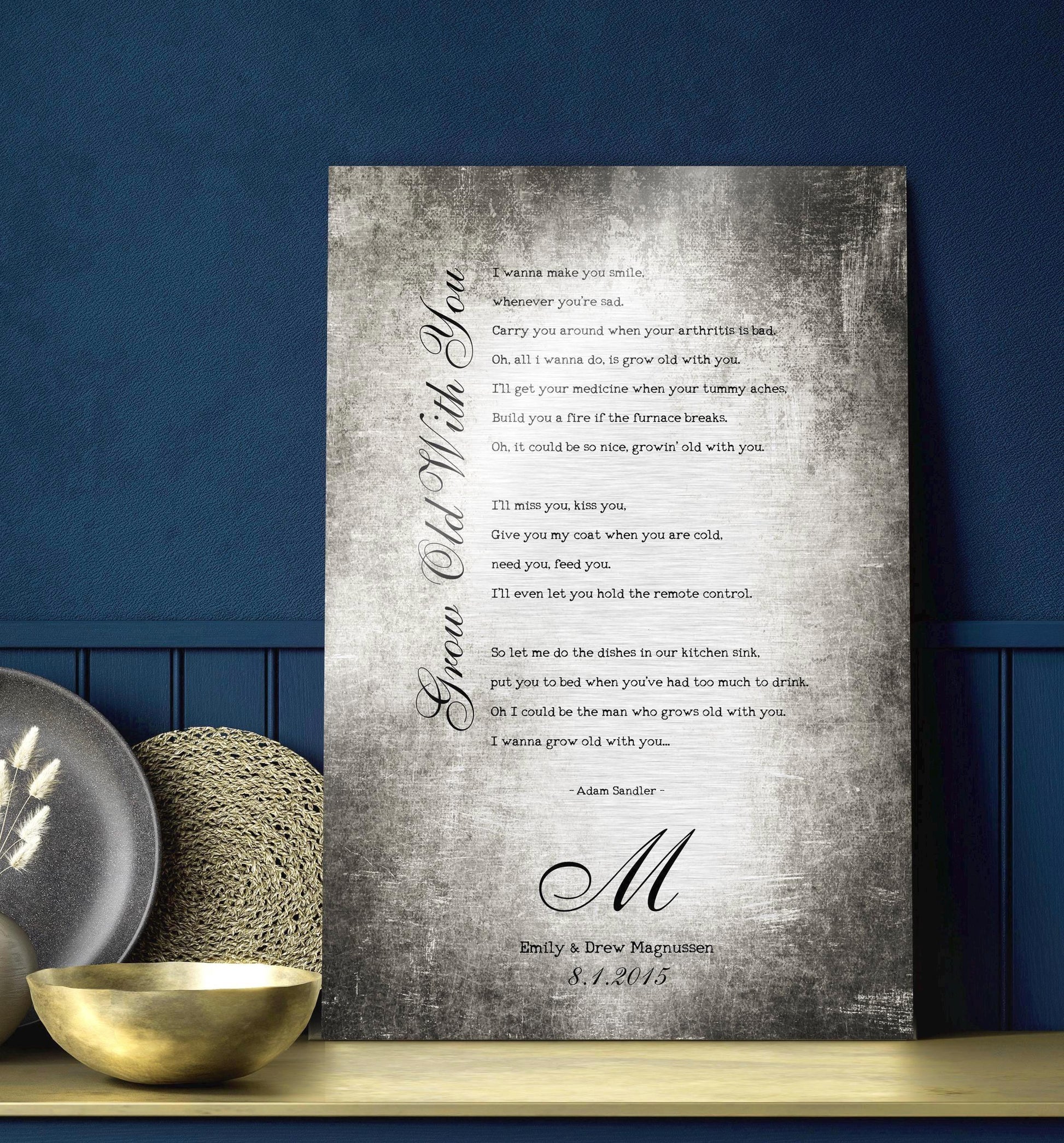 Couples custom song lyrics wall decor - vintage metal tin aluminum song plaque sits on a navy background on a counter top. The sign features the inscription “Grow Old With You” in an elegant calligraphy running vertically up the side of song lyrics in a stanza format - which is an except from the lyrics. Beneath is a last name Monogram letter, names and a union date, for posterity.    Photo courtesy of Honeycomb Proverbs