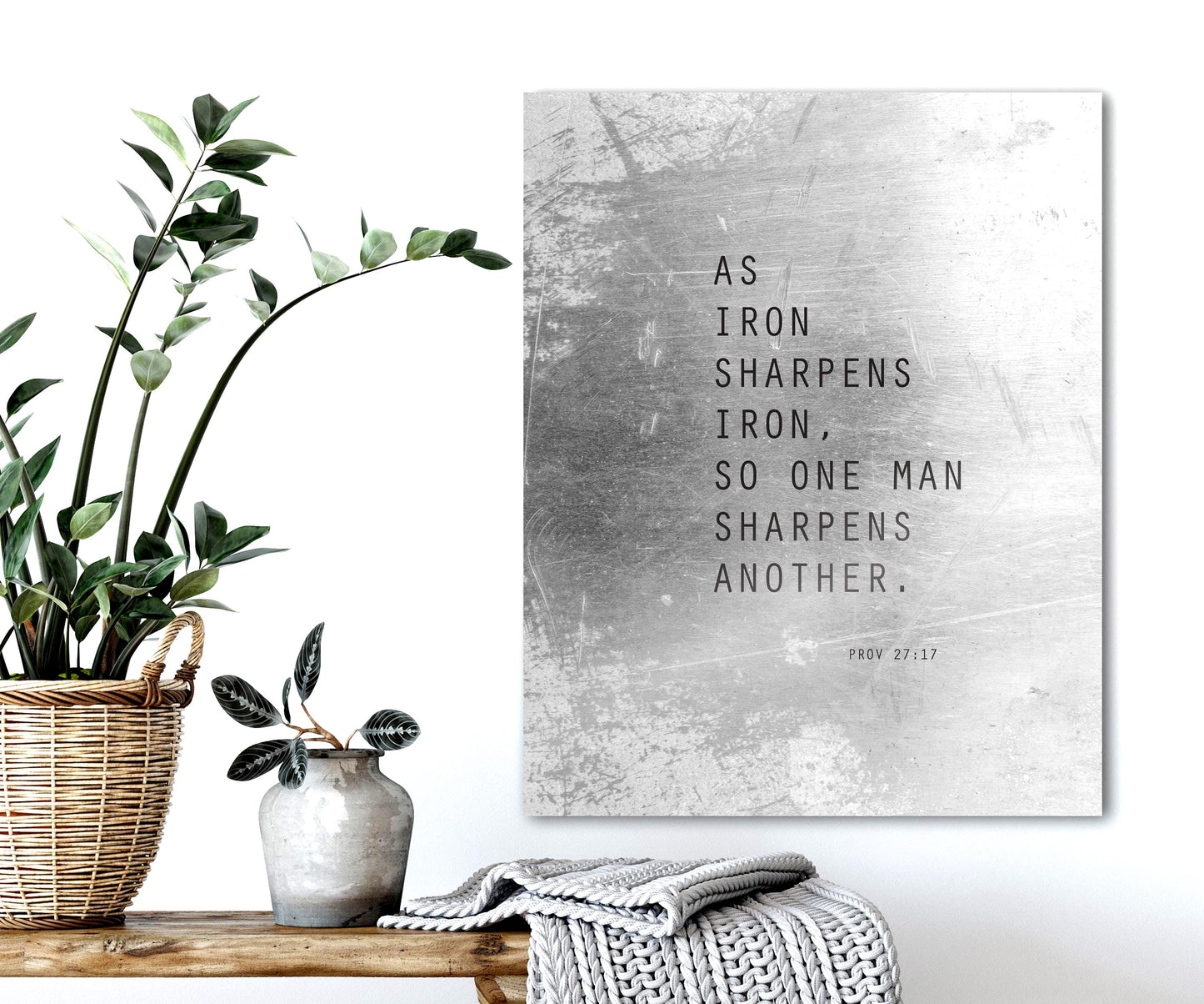 As iron sharpens iron, so one man sharpens another, is inscribed on a tarnished and distressed aluminum metal sign and hung on a wall above a bench.

Photo courtesy of Honeycomb Proverbs