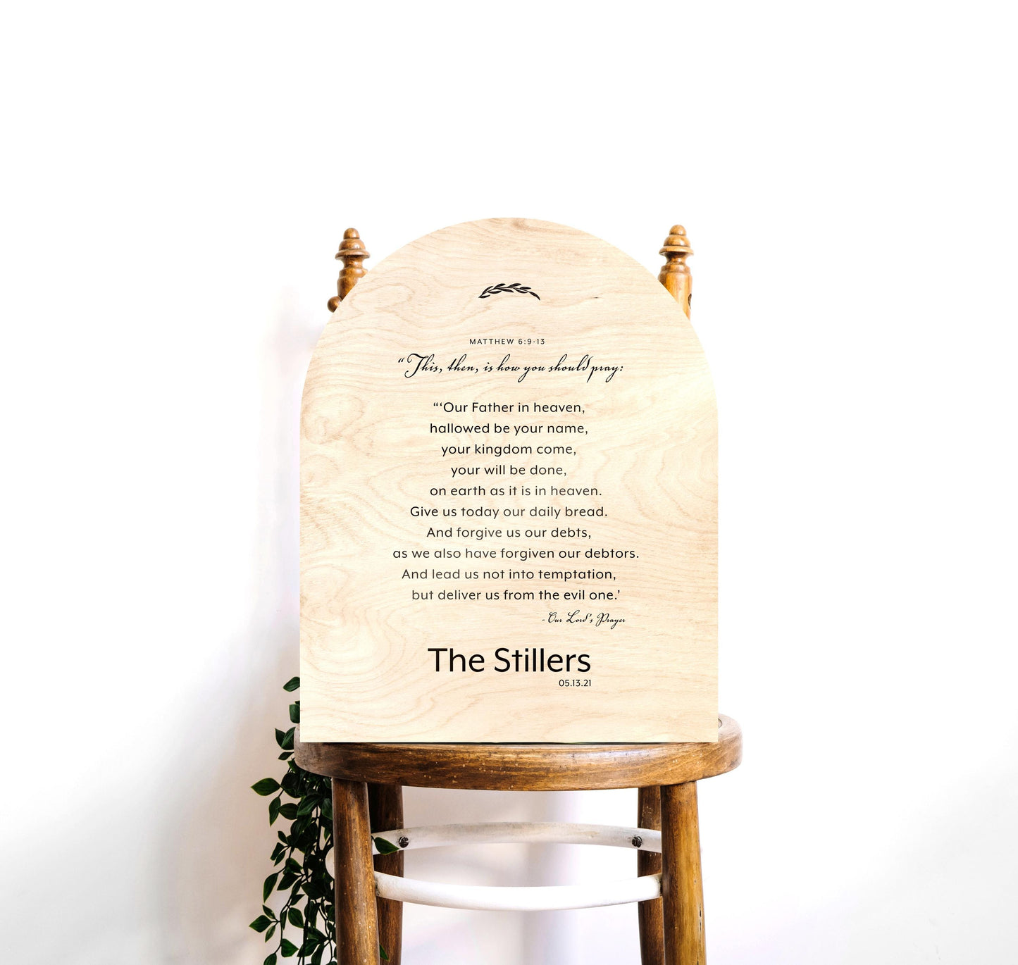 Wood arched The Lord's Prayer Plaque and Family Name sign, Verses of Matthew 6:9-13 are centered in stanza format with a family name "Thompson" beneath. A decorative botanical motif accents the top of the plaque.