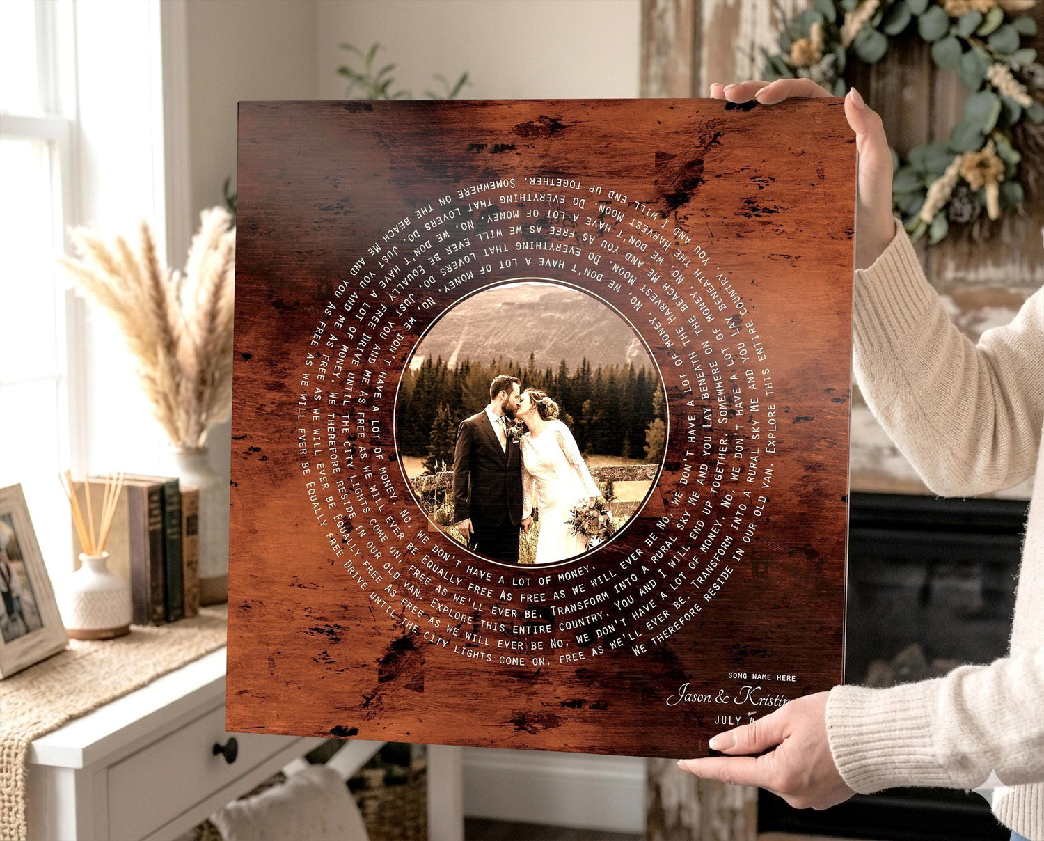 Bronzed photo plaque with custom song lyrics, and names and date. A photo is in the center as a vinyl record design with song lyrics spiraling around it. The photo is a wedidng photo of a couple kissing and the plaque also features the names and wedding date of the couple in the photograph. It's being held by someone who is off camera.